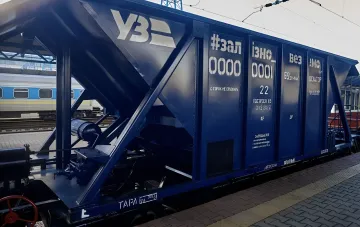 Blue Ukrzaliznytsia freight car parked at a railway station