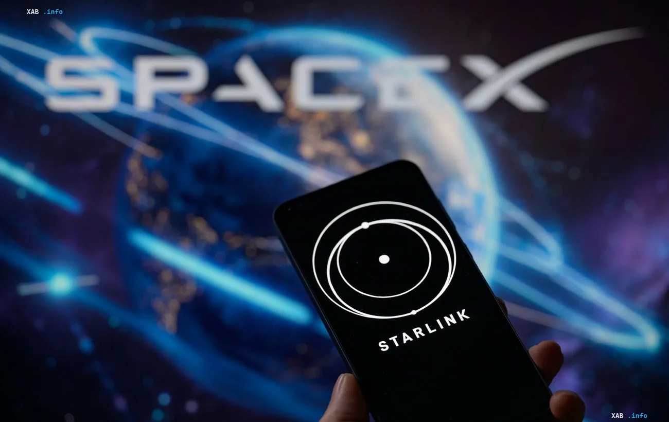 Человек держит смартфон с логотипом Starlink на фоне логотипа SpaceX
