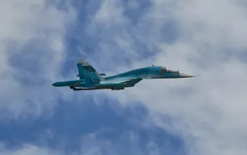 Russian Su-34 fighter-bomber in flight against a cloudy sky background
