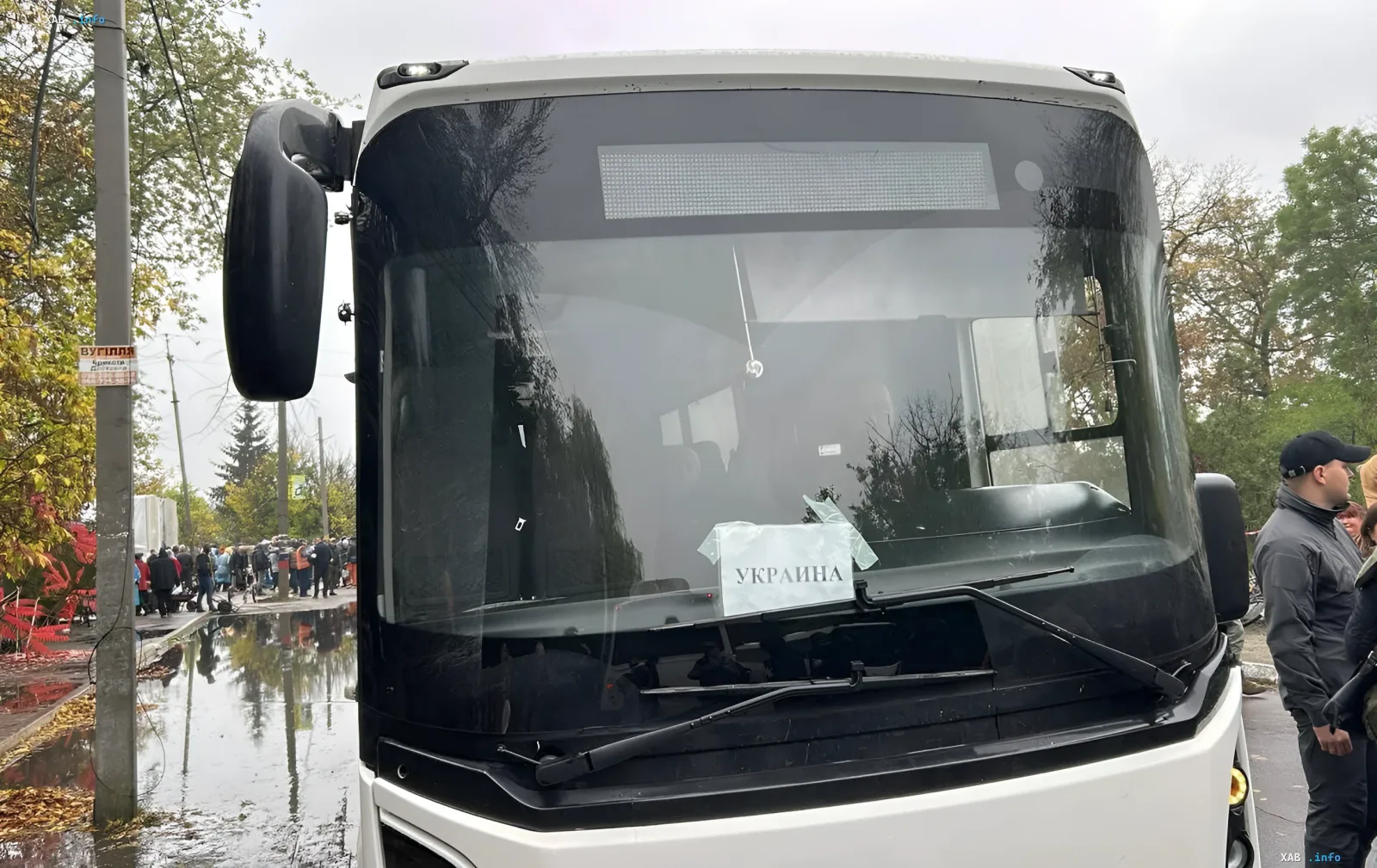 Weißer Bus mit Ukraine-Aufschrift an der Windschutzscheibe vor Evakuierung der Bewohner in Oleschki
