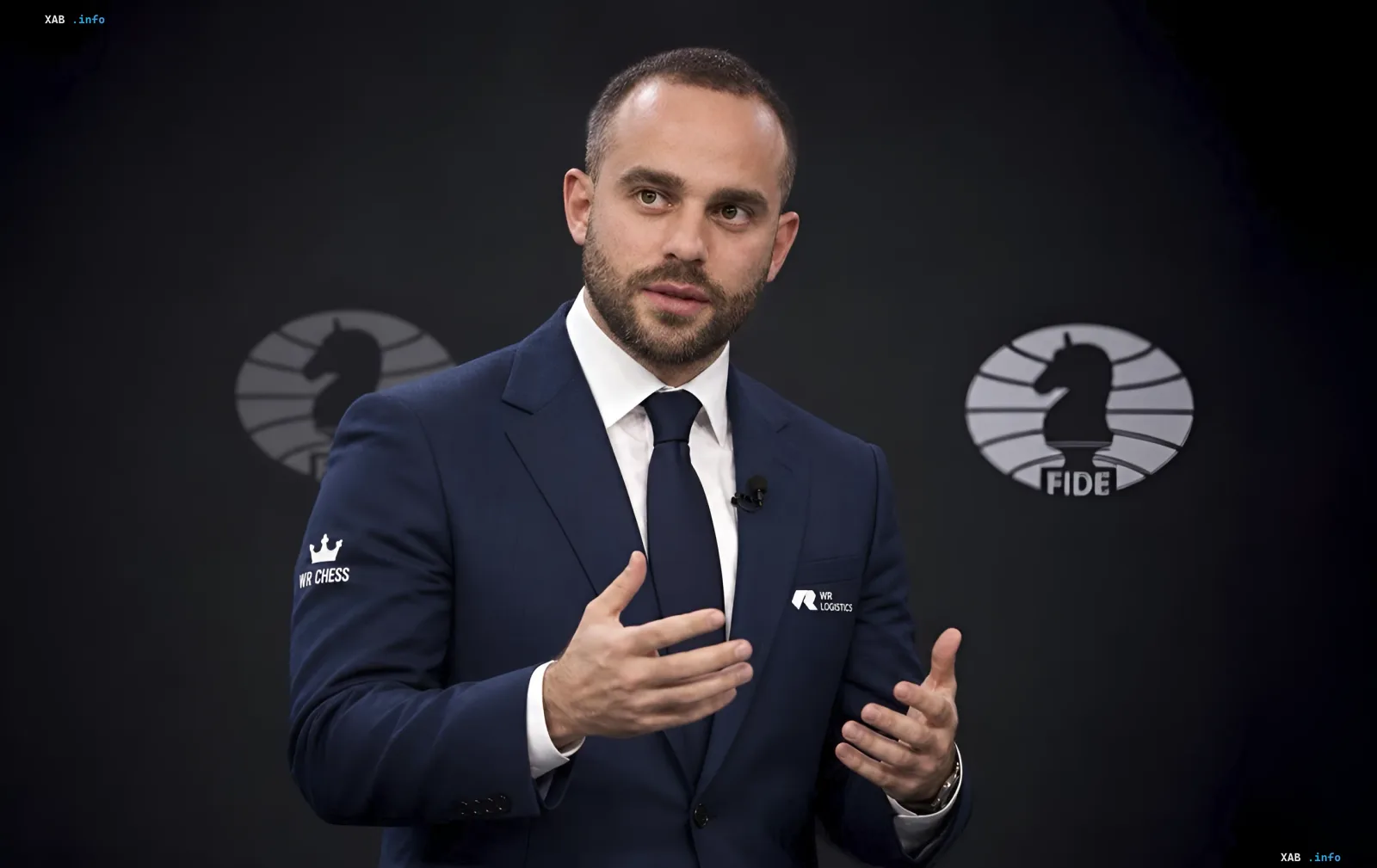 Вадим Розенштейн выступает на фоне логотипа FIDE во время избирательной кампании