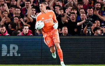 Real-Madrid-Torhüter Andriy Lunin läuft mit einem Ball in den Händen über den Rasen