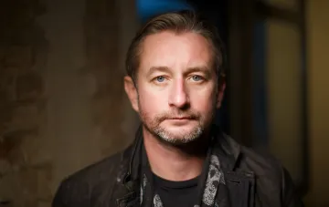 Portrait of Ukrainian writer and musician Sergiy Zhadan with a beard and jacket