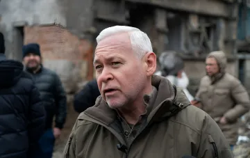 Мэр Харькова Игорь Терехов дает комментарий на фоне разрушенного войной здания