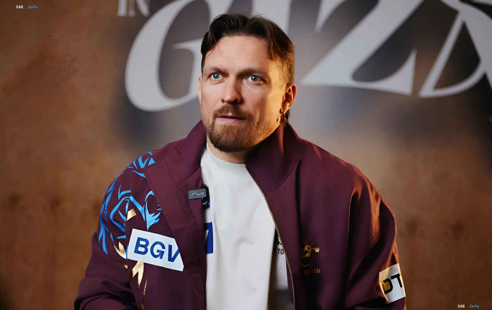 Ukrainian boxer Oleksandr Usyk giving an interview in a burgundy sports jacket