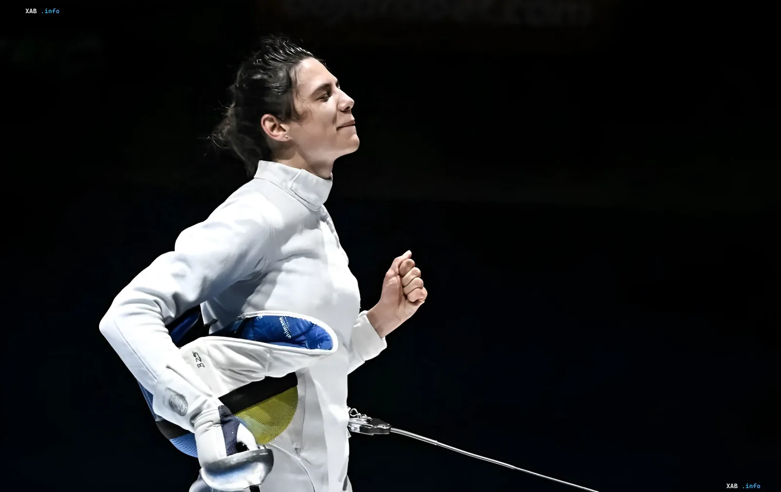 Ukrainian fencer Vlada Kharkova in a white suit celebrating her victory