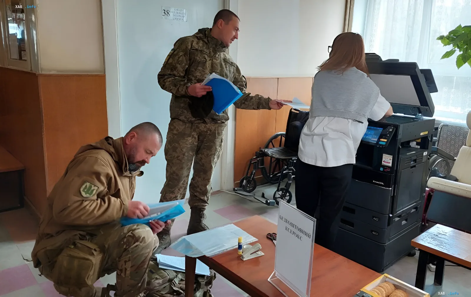 AFU servicemen and a woman working with documents and a copy machine in a medical facility