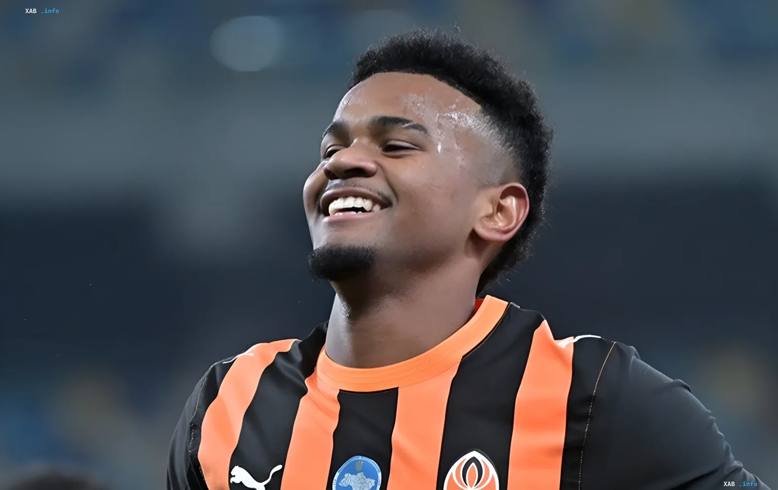 Shakhtar winger Alisson Santana smiling happily in the club's official orange and black kit