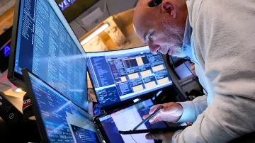 Trader an mehreren Monitoren überprüft Kryptowährungsbörsendaten