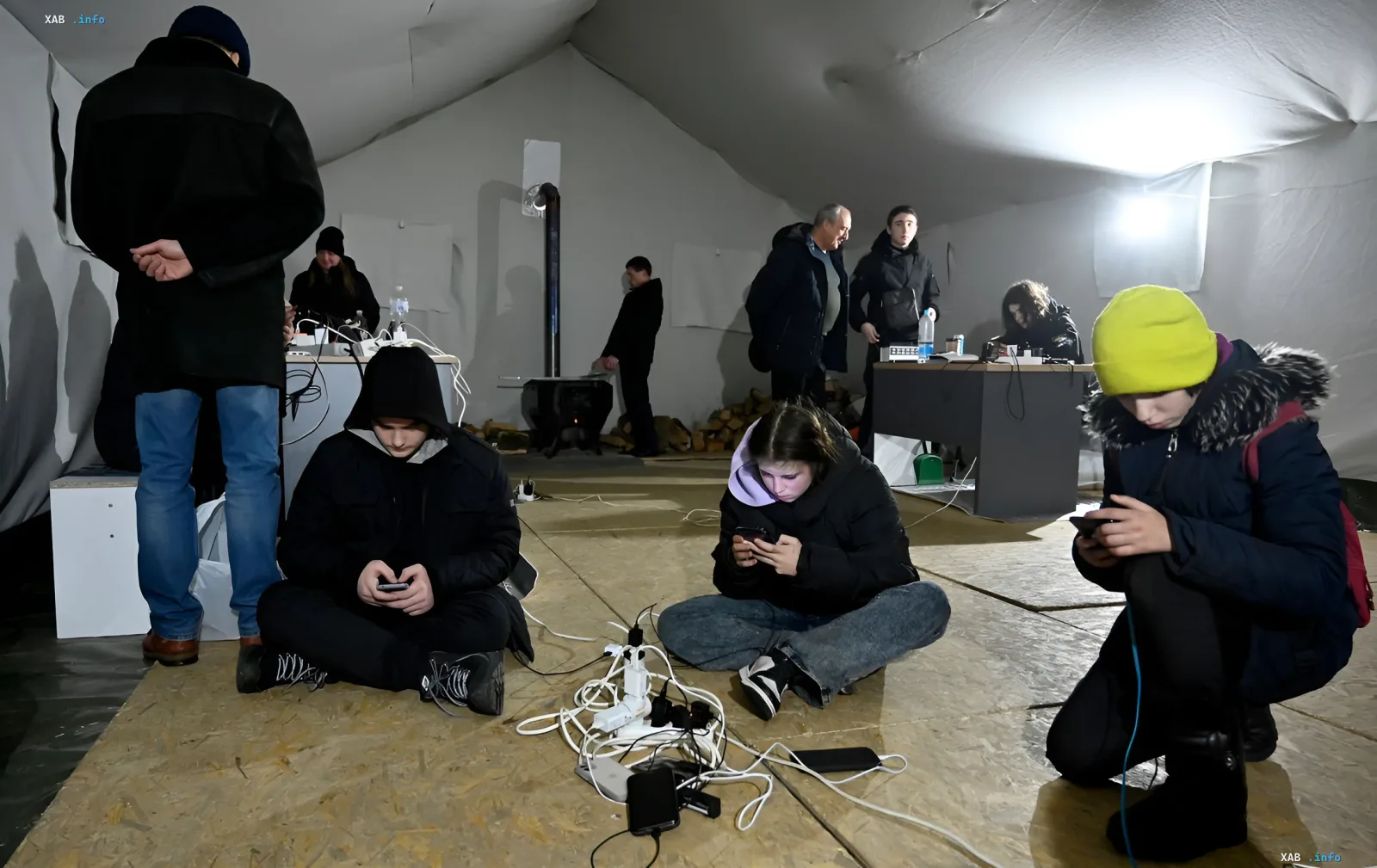 People charging smartphones from power strips at an invincibility point during a blackout
