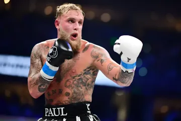 American boxer and content creator Jake Paul with tattoos in the ring wearing boxing gloves