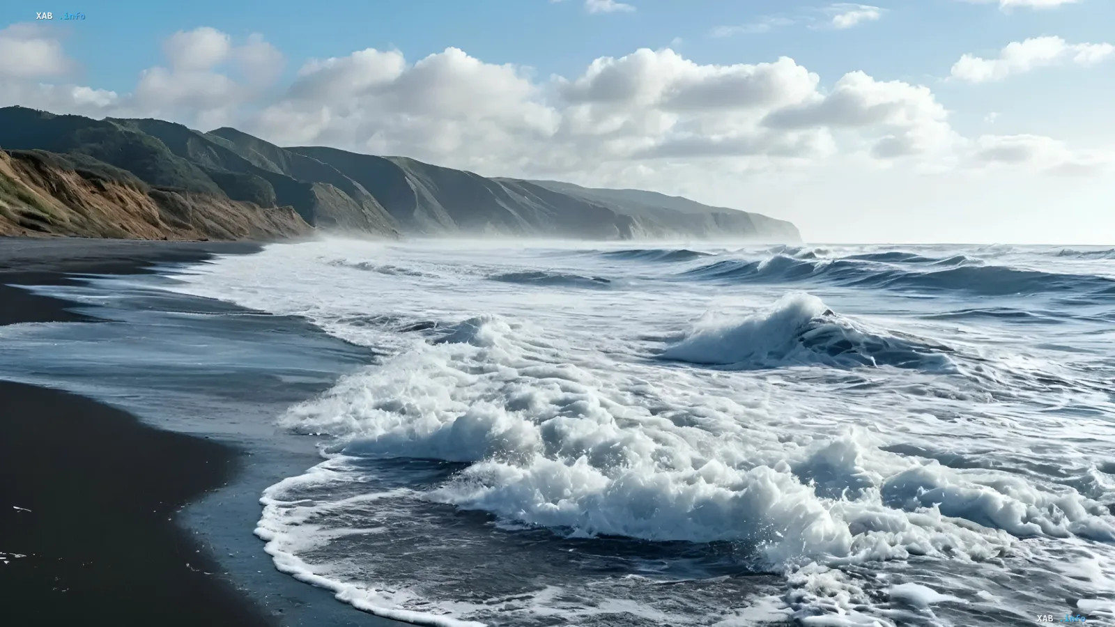 Powerful waves crash onto a black sandy beach under a cloudy sky near rocky hills