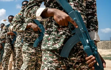 Soldaten in Tarnuniform halten Waffen an einer Position
