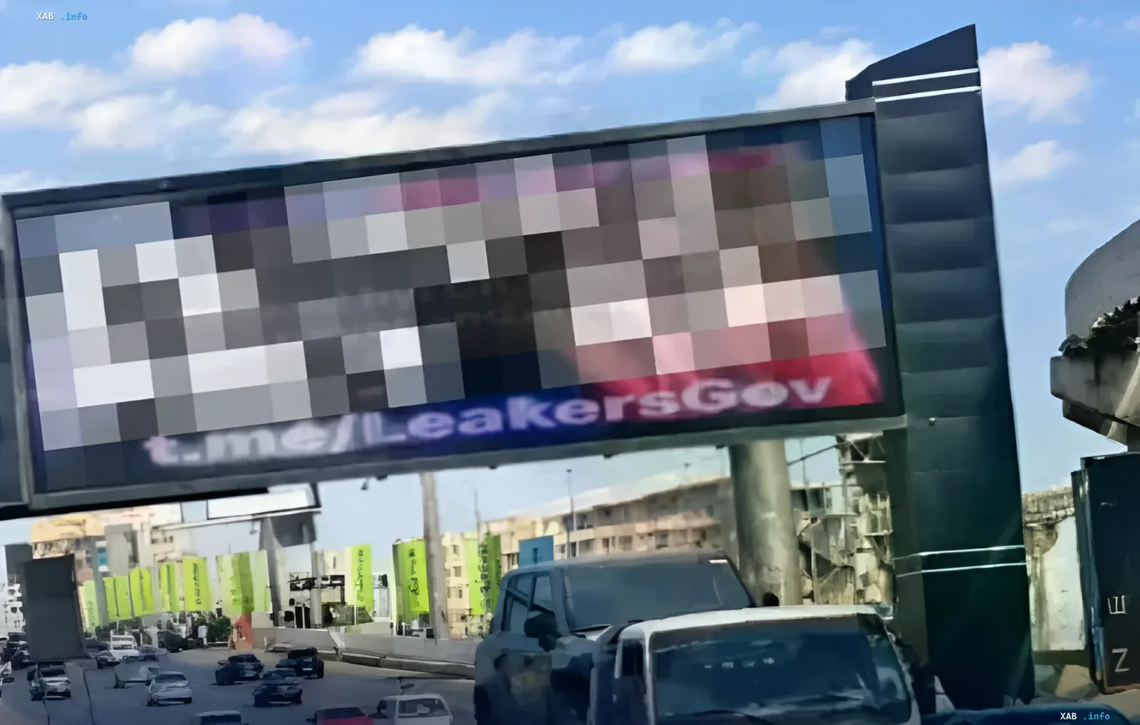 Electronic billboard on a busy Cairo highway with pixelated pornographic content and a Telegram link