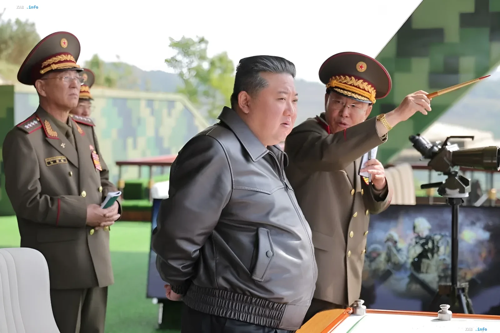 North Korean leader Kim Jong Un in a black leather jacket inspects a military exhibition surrounded by generals.