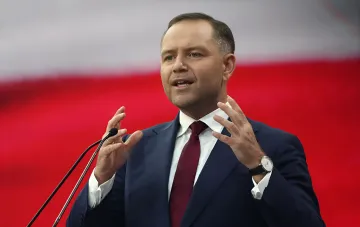 Президент Польши Кароль Навроцкий выступает с эмоциональной речью на фоне государственного флага
