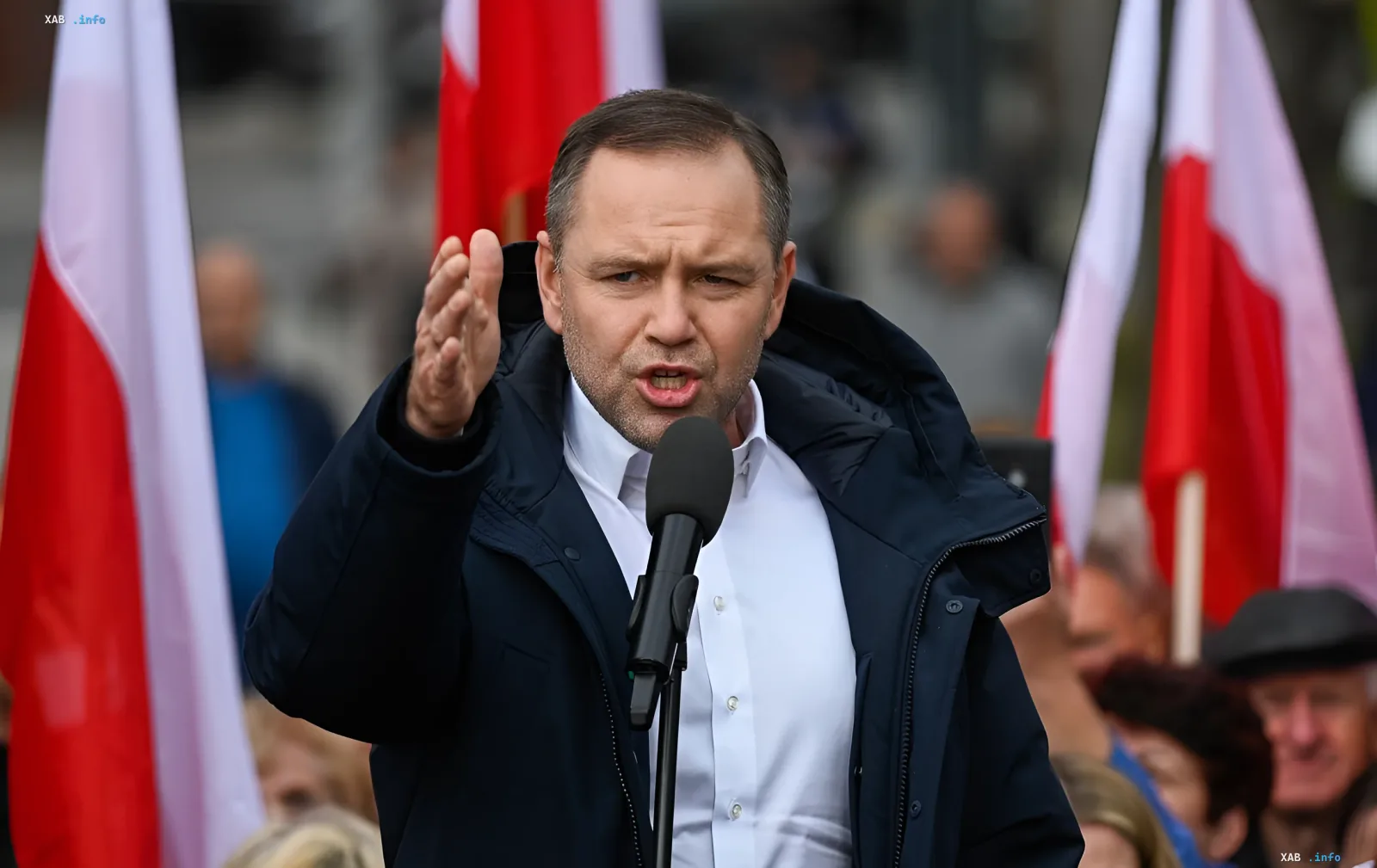 Polens Präsident Karol Nawrocki hält eine Rede bei einer politischen Kundgebung vor dem Hintergrund polnischer Flaggen.