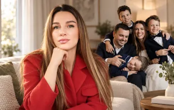 A beautiful woman in the foreground and a happy large family in a cozy living room
