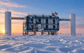Antarctic scientific station IceCube in a snowy desert under the sunset sky